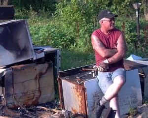 Jeff Roggeman pauses for a break while cutting metal from burned up mobile homes at the Rayburn Mobile Home Park.