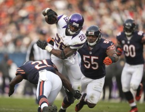 Minnesota Vikings' Adrian Peterson dodges a hit by Chicago Bears' Major Wright early in the fourth quarter at Solider Field on Sunday, November 25, 2012, in Chicago, Illinois. The Bears defeated the Vikings, 28-10.
