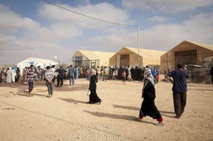 Syrian refugees wait at a UNHCR distribution centre in Za