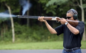 President Obama fires a gun in this White House photo.