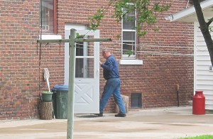 A man follows DCI agents back into the house located at 103 15th SE in Mason City.