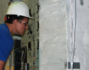 Grant Schmitz studies a concrete test panel for signs of cracking under heavy loads. Photo by Mike Krapfl.