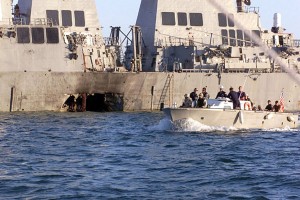 (October 18, 2000 FILE PHOTO) :  U.S. Navy and Marine Corps security personnel patrol past the damaged U.S. Navy destroyer USS Cole  following the October 12, 2000 terrorist bombing attack on the ship in Aden, Yemen.