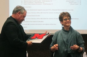 Mark Becker accepts an award presented by Superintendent Anita Micich for his years of service to the school district