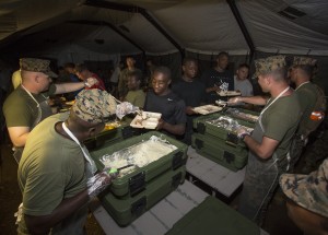 Marines serve food for Thanksgiving Nov. 28 at Tinian's North Field during exercise Forager Fury II. The United Services Organization provided more than 58 boxes of food to Tinian and Guam to help raise the morale of service members. The purpose of FFII is to employ and assess combat power generation and sustainment in a deployed, austere and unimproved environment. The Marines are with 1st Marine Aircraft Wing, III Marine Expeditionary Force. (U.S. Marine Photo by Lance Cpl. Antonio J. Rubio/Released)