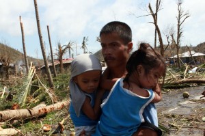 A man carrying his children in Tacloban, Leyte, Philippines, after Super Typhoon Haiyan (local name Yolanda) hit the province. Photo: UNICEF