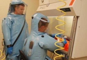 Ebola virus research is conducted in maximum containment Biosafety Level 4, or BSL-4, laboratories, where investigators wear positive-pressure suits and breathe filtered air as they work. Here, scientists Gene Olinger (L) and James Pettit demonstrate BSL-4 laboratory procedures in BSL-4 training laboratory at US Army Medical Research Institute of Infectious Diseases (USAMRIID), Fort Detrick, Md. (Credit: USAMRIID courtesy photo)