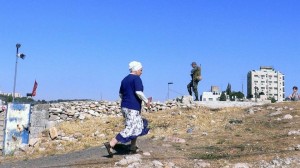 A settler woman walks past an Israeli soldier standing guard in East Jerusalem. Photo: IRIN/Andreas Hackl (file photo)