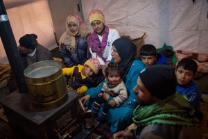 Members of a Syrian refugee family huddle around a stove inside their shelter days ago in Lebanon’s Bekaa Valley. Photo: UNHCR/A. McConnell Members of a Syrian refugee family huddle around a stove inside their shelter days ago in Lebanon’s Bekaa Valley. Photo: UNHCR/A. McConnell