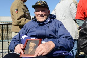 Army veteran Hugh Phelps holds a picture of his brother Patrick, an Army veteran, on his lap atop a folded American flag, as he visited the World War II Memorial in Washington, D.C., April 5, 2014. Phelps, of Ellicott City, Md., visited the memorial with the Honor Flight Capital Region.