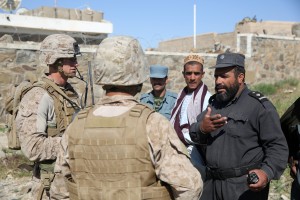 Captain Scott Stewart, left, commanding officer, Weapons Company, 1st Battalion, 7th Marine Regiment, and a native of El Cajon, Calif., is assisted by an Afghan interpreter to gather intelligence from an Afghan police officer during a mission in Helmand province, Afghanistan, April 17. The company's two-day mission was to disrupt lethal enemy aid and to search three compounds of interest in an area suspected of Taliban influence. The compounds were suspected to contain a homemade-explosive lab, a cache for narcotics and be home to local Taliban leadership.