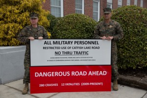 MARINE CORPS BASE CAMP LEJEUNE, N.C. - Col. James W. Clark, deputy commander of Marine Corps Installations East, and Sgt. Maj. Ernest K. Hoopii, Marine Corps Installations East sergeant major, display the new Catfish Lake Road warning sign aboard Marine Corps Base Camp Lejeune, March 6. It was deemed off-limits to base personnel due to the dangerous driving conditions.