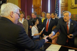 Senator Schoenjahn takes a pen from Governor Terry Branstad during the signing  of a bill on dyslexia earlier this month