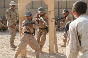 Cpl. Tyler M. Rousselle, a Joint Security Academy Southwest instructor, critiques three Afghan National Police recruits practice room-clearing exercises during military operations on urban terrain training at Camp Leatherneck, Afghanistan.