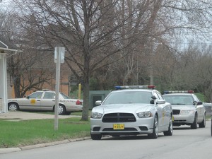 Patrol cars sit as officers surround the residence at 1316