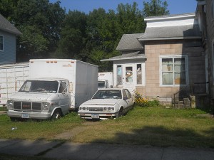 More trucks in the back yard, and car that doesn't appear to run