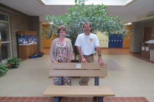 Allison Stevenson, Roosevelt Elementary School principal, and Todd Von Ehwegen, Co-Chair of the Mason City Earth Day Committee, with a recycled plastic bench won by Roosevelt in a milk jug collecting contest for the annual Earth Day Event.