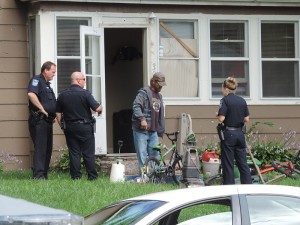 Male subject continues to unload the house.  Police watch.