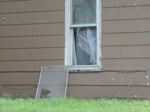 Broken, open window with torn plastic, as described in the call to police.  The screen appears to be torn as well.
