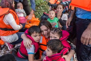 A Syrian mother cries with relief as she embraces her three young children after a rough sea crossing. UNHCR/Ivor Prickett