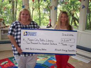 Mary Markwalter, Library Director accepts the award from Rebecca Gisel, Key Account Manager for Alliant Energy